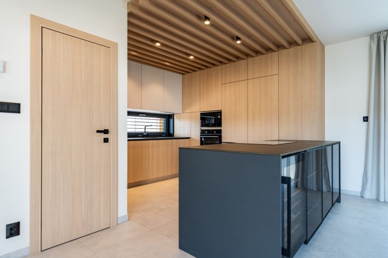 A kitchen in a family house with a wooden decor floor and modern lighting.