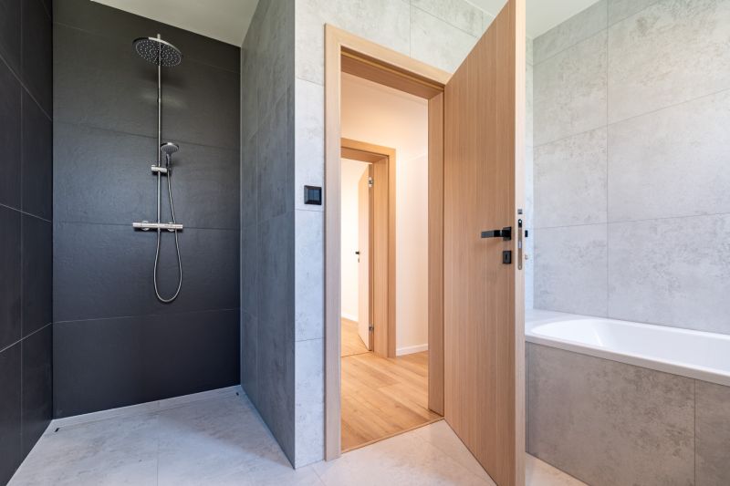 A stylish bathroom in a family house with a bathtub, shower, and tiles.