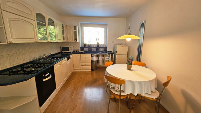 A bright kitchen in a 2-room apartment with a gas stove and a wooden decor floor.