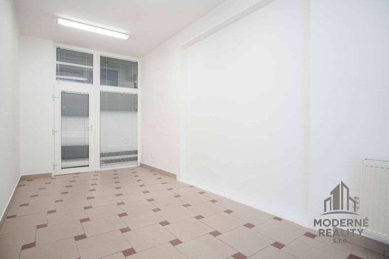 Offices with white walls, tiles, and glass doors create a clean space.