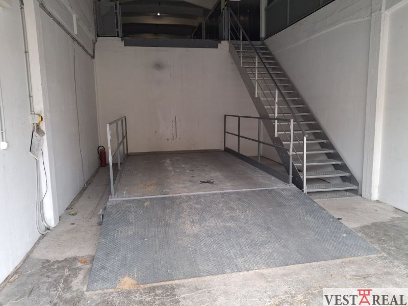 Warehouses and halls with a metal platform and staircase, white walls, industrial appearance.