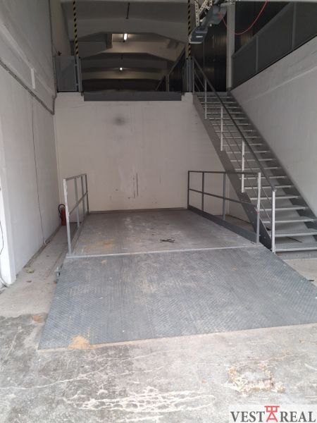Interior of warehouses with a ramp and metal staircase; Warehouses and halls.