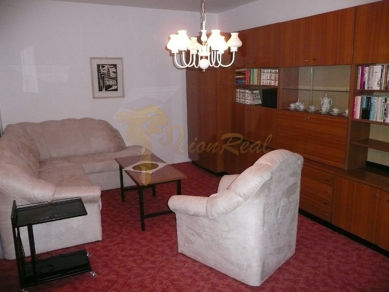 Living room in a two-room apartment with comfortable sofas and a red carpet.