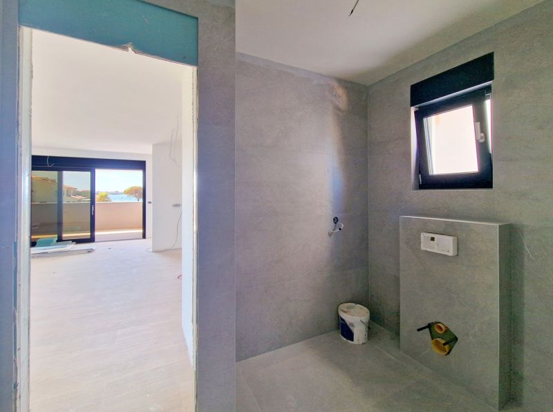 Bathroom with modern tiles in a 3-room apartment, view of the terrace.
