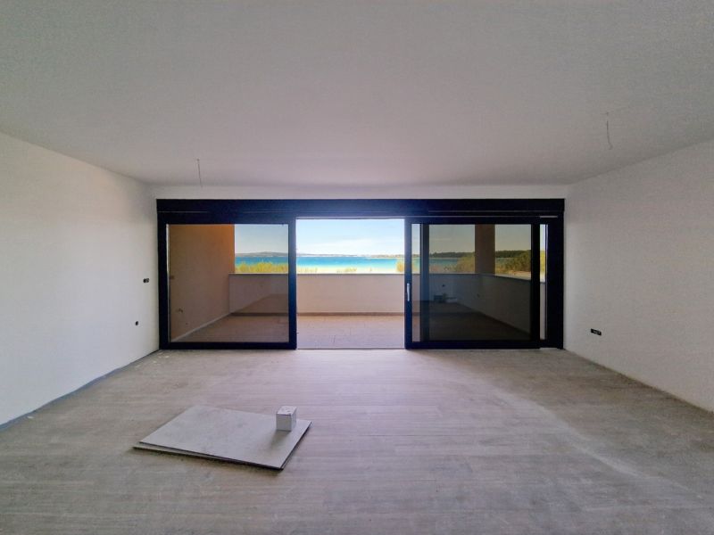 Living room of a three-room apartment with a glass wall and a floor with a wooden decor.