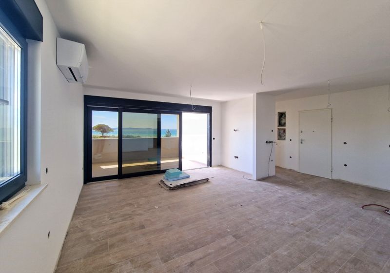 Spacious living area with wood-patterned flooring in a 3-room apartment.
