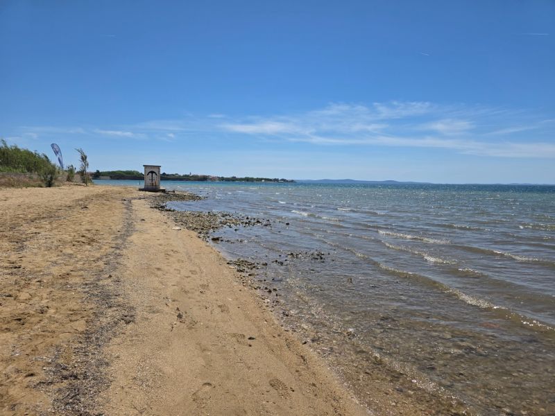 A beach with golden sand and calm sea in the town of Privlaka.
