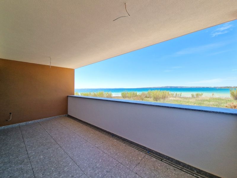 A balcony with a view of the beach and sea in a 3-room apartment in Privlaka.