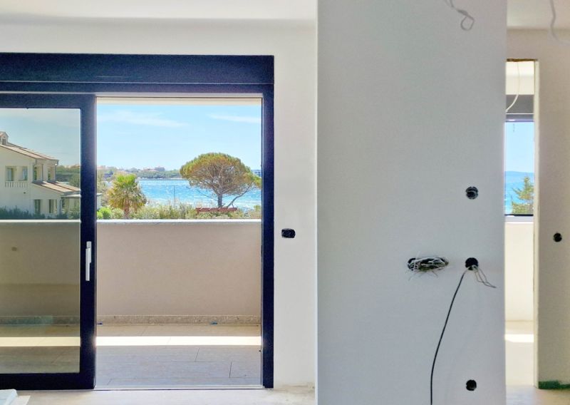 View from a 3-room apartment of the sea with trees and houses in Privlaka.