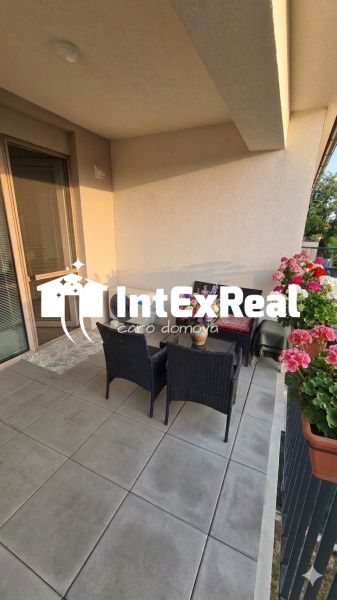 In the exterior of a 1-room apartment in Šoporňa, there is a terrace with seating and flowers.