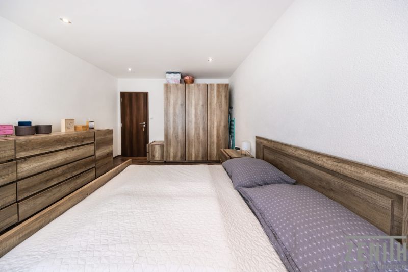 Bedroom in a 3-room apartment with wooden furniture and flooring with a wooden decor.
