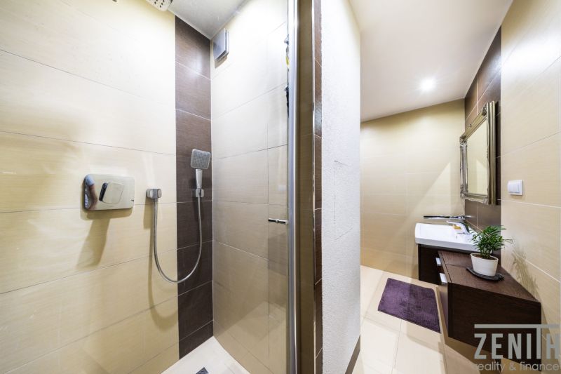Bathroom with a shower, light tiles and a sink, 3-room apartment.