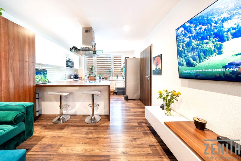 3-room apartment with a kitchen and wooden decor flooring, bar stools, sofa.