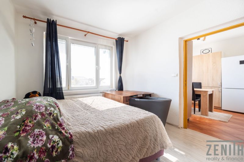 A bright room in a 3-room apartment with a bed and a spacious window.
