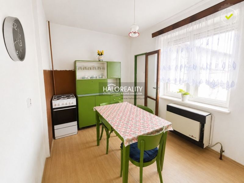 A kitchen in a family house with retro furniture and a wooden decor floor.