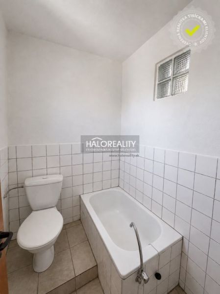 Bathroom in a family house with a bathtub, toilet, and white tiles.