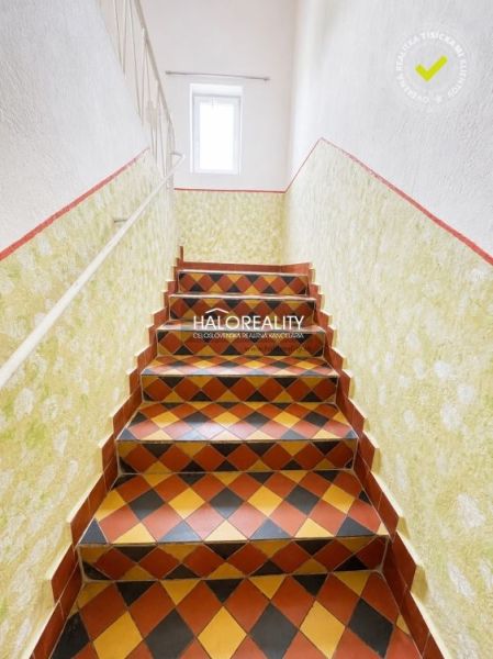 Interior of a family house with colorful tiles on the stairs and white walls.