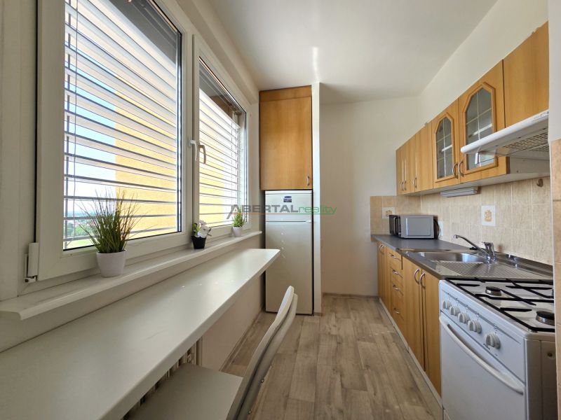 A kitchen with wooden decor and appliances, suitable for a studio apartment.