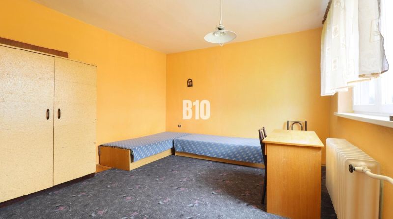 A room in a family house with blue beds, a desk, and a carpet.
