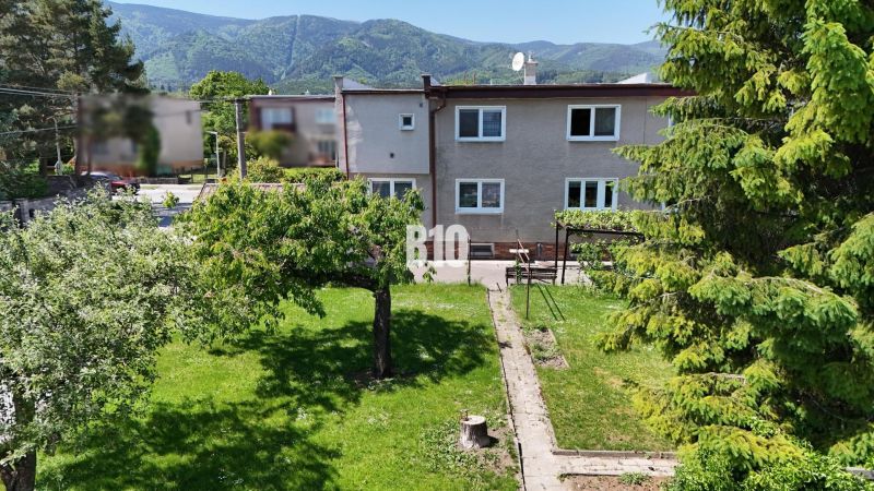 A family house in Martin with a spacious garden and mountains in the background.