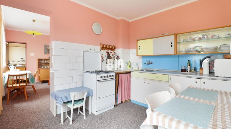 A kitchen in a family house with retro furniture, colorful cabinets, dining table.
