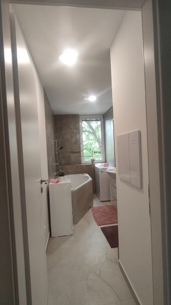 Bathroom with a shower and a bathtub in a 4-room apartment, light tiles and flooring.