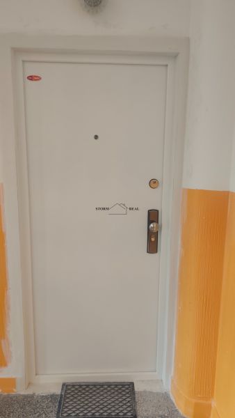 White entrance door in a 4-room apartment with a security lock.