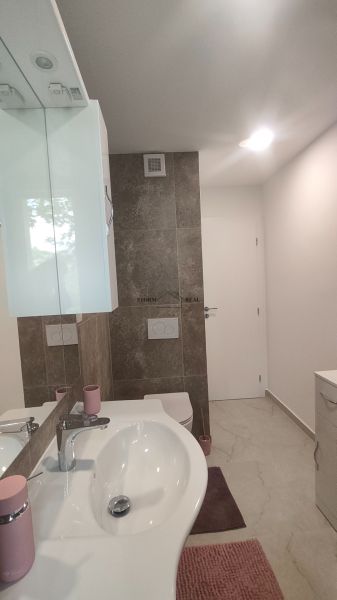 Bathroom in a 4-room apartment with a sink, mirror, and toilet.