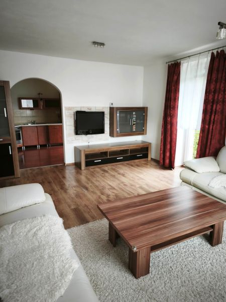 Living room in a family house with a sofa, table, and floor with a wooden decor.