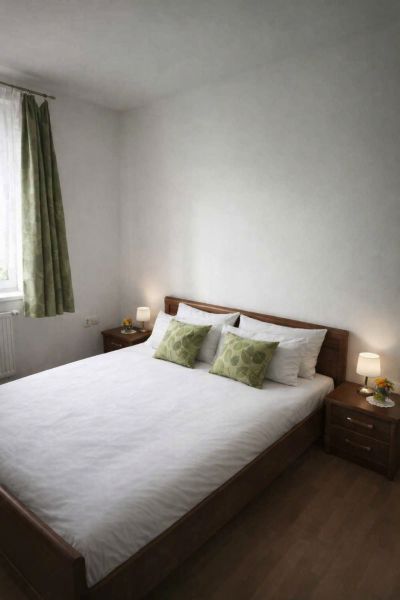A bedroom in a family house with a double bed, wooden decor flooring, and decorative pillows.