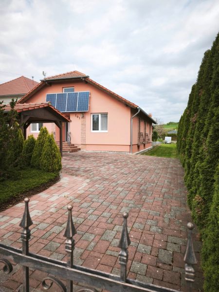 A family house in Martin nad Žitavou on Hlavná Street with solar panels and a paved courtyard.