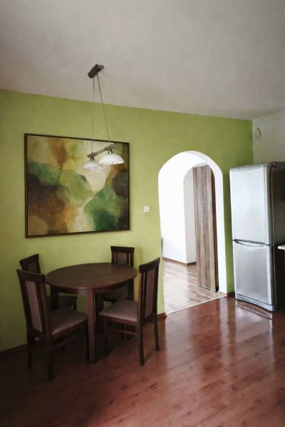 Dining area in a family house with a wooden decor floor and a colorful painting.
