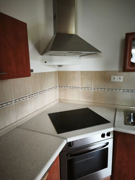 A kitchen in a family house with a stainless steel extractor hood and an electric cooktop.