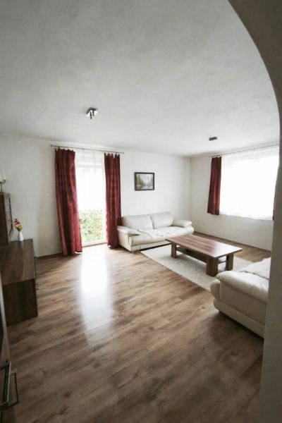 Living room in a family house with sofas, a coffee table, and a wooden decor floor.