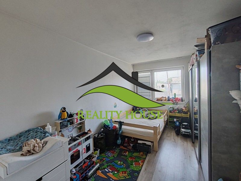 Children's room with light walls and a wooden decor floor in a 3-room apartment.
