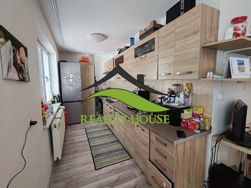 A kitchen with wooden decor in a 3-room apartment, equipped with appliances and storage space.
