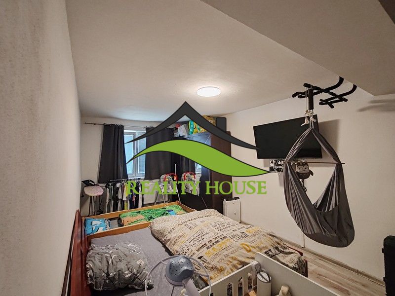 A children's room in a three-room apartment with a bed and a TV on the wall.