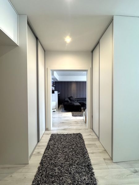 A hallway with built-in wardrobes and a floor with a wood decor in a 4-room apartment.