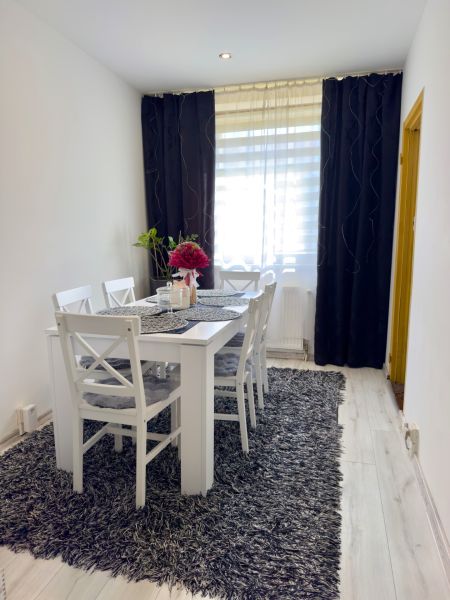 Dining room with a gray carpet and white furniture in a 4-room apartment.