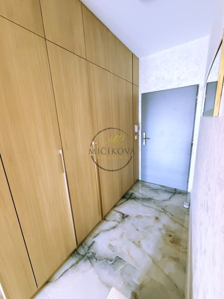 A hallway in a 2-room apartment with storage spaces and a marble-patterned floor.