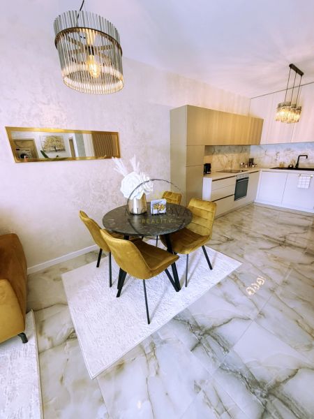 Dining area in a 2-room apartment with marble flooring and elegant lighting.