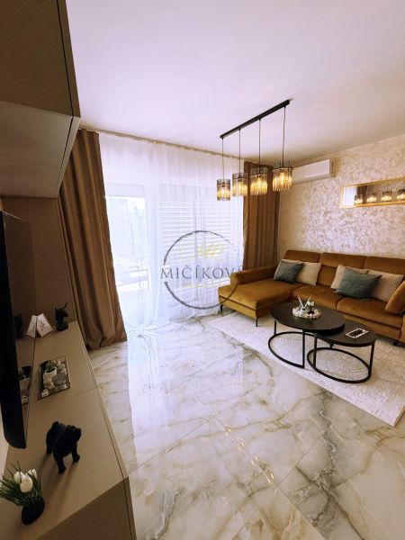 Living room in a two-room apartment with glossy tiles and a sofa.