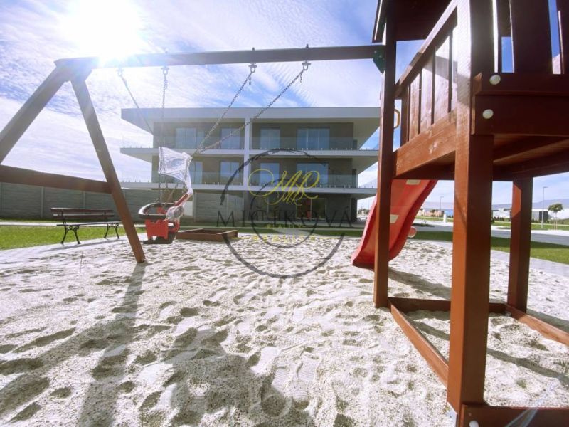 A children's playground with sand near a 2-room apartment in Galanta, with a slide and a swing.