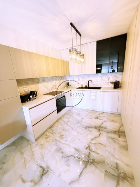 A kitchen in a 2-room apartment with marble flooring and minimalist furniture.