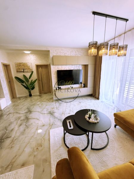 Living room in a two-room apartment with marble flooring and stylish lighting.