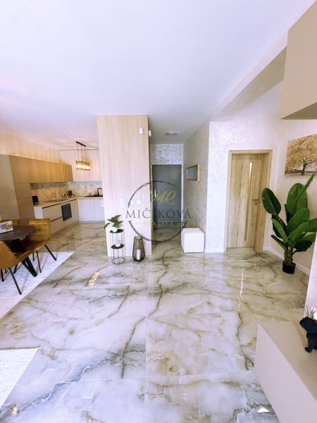 Interior of a 2-room apartment with a marble floor, bright kitchen, and dining area.