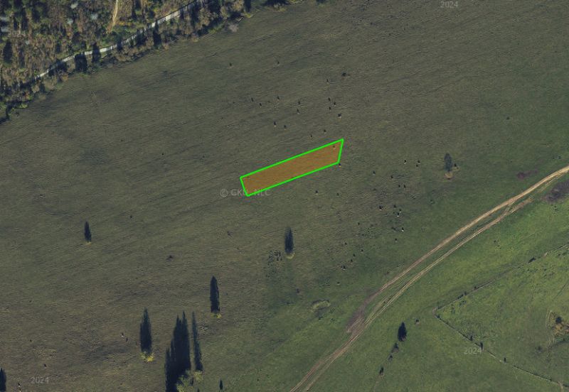 Agricultural and forest land in Čierny Balog with visible grassed area and road.