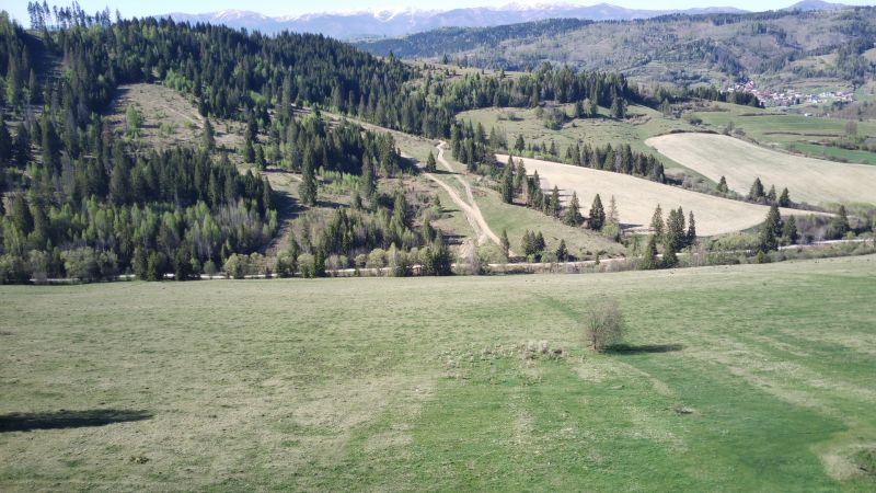 Agricultural and forest land in Čierny Balog with hills, forests, and a road in the countryside.