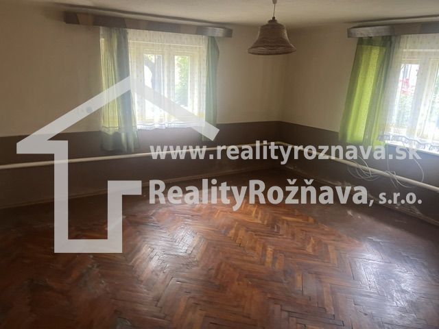 Interior of a family house with a wooden decor floor and green curtains.