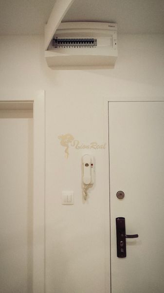 White entrance hallway in a 4-room apartment with a phone and doors.
